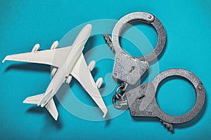 Airplane and handcuffs on the table. Concept on the topic of hooliganism on board an aircraft photo