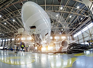 Airplane in the hangar for maintenance, bottom nose view