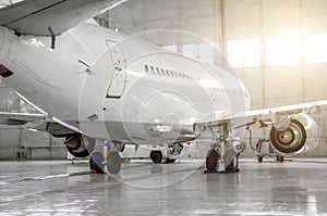 Airplane in hangar, rear view of aircraft and light from windows.