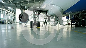 Airplane in hangar, rear view of aircraft and light from windows. Business jet airplane is in hangar. The airplane in