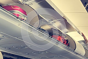 Airplane interior with overhead luggage compartment.