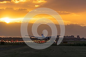 Airplane almost landed during a nice sunrise.