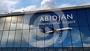 Airplane landing at Abidjan Ivory Coast airport mirrored in terminal