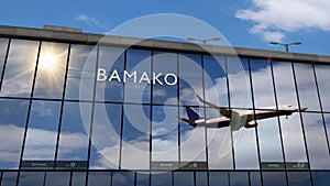 Airplane landing at Bamako Mali airport mirrored in terminal