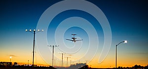 Airplane landing during dawn just before sunrise