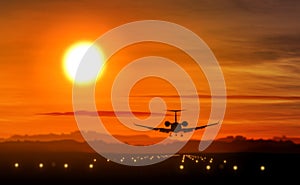 Airplane landing - private jet silhouette on sunset