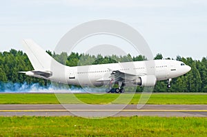 Airplane landing on the runway at the airport with smoke from the chassis. Hard landing.