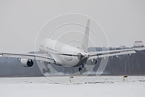 Airplane landing on runway with smoke from chassis in winter time. Touchdown with landing gear smoke