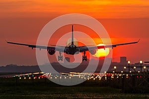 Airplane is landing during sunrise.