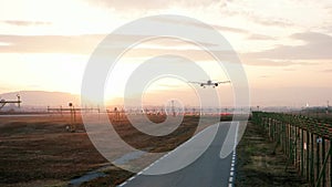 Airplane lands at the airport, Plane at sunset, plane flies low preparing for landing at airport,