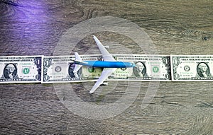 The airplane lies on a strip of one dollars. Landing strip for airplanes of dollars