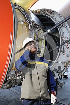 Airplane mechanic with large jet engine turbine