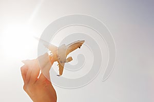 Airplane model in hand on sunny sky. Concepts of travel, transportation