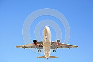 Airplane overhead against blue sky