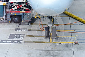 Airplane parked at airport terminal serviced by ground crew preparing for a flight photo