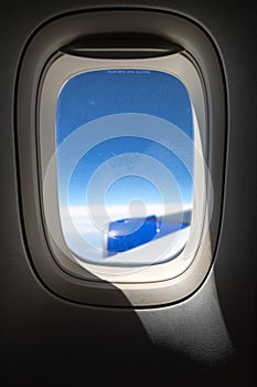 Airplane porthole with view on the airplane wing