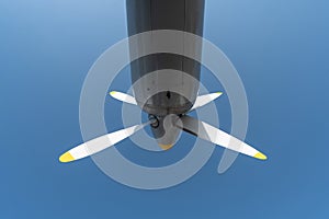 Airplane propeller of military aircraft, copy space. Blue sky background