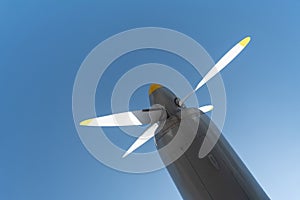 Airplane propeller of military aircraft, copy space. Blue sky sunny background