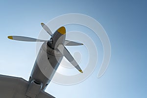 Airplane propeller of military aircraft, copy space. Blue sky sunny background