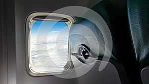 Airplane seat and windows inside an aircraft. Clouds airplane passenger window