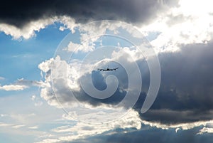 Airplane silhouette flying away against in dramatic sky