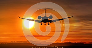 Airplane landing - private jet silhouette on sunset