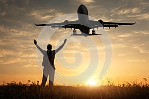 Airplane and silhouette of a standing happy man