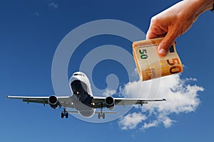 Airplane with sky and cloud background and money in hand