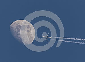 Airplane on sky in front of moon