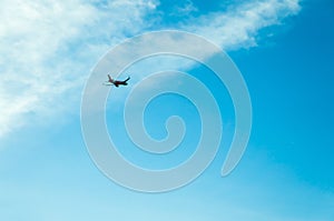 A plane in the cloudy blue sky