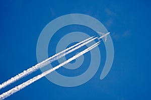 Airplane in the sky with a trace of steam contrail.
