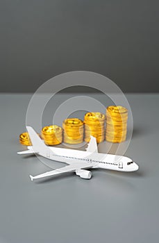 An airplane and a stack of coins symbolizing growth. photo