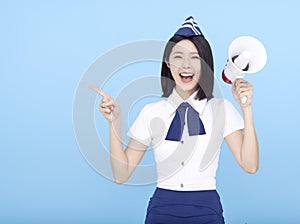 Airplane stewardess  woman shouting through the megaphone isolated on blue background