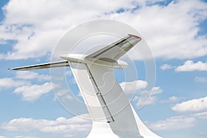 Airplane tail close-up. Aircraft part against blue sky with clouds background. Copyspace