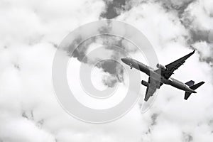 Airplane take-off from runways at cloudy sky. Black and white