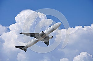 Airplane is takinf off under fluffy clouds in the sky photo