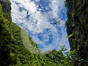 Airplane taking off , fly over the mountain view. Silhouette of a big passenger or cargo aircraft, airline on cloudy blue sky.