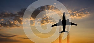 Airplane taking off at sunset. Silhouette of a big passenger or cargo aircraft, airline. Transportation