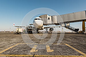 Airplane at the terminal gate prepearing for takeoff - Modern international airport during sunset - Concept of fun