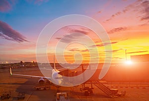 Airplane at the terminal gate ready for takeoff. International airport during colorful sunset - Concept  Travel around the world