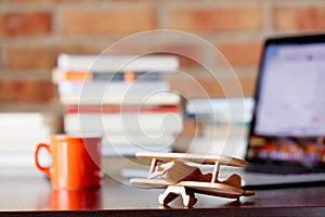 Airplane toy on a table with books and laptop computer