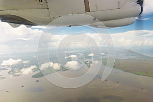 Airplane transport concept. View on the left wing passenger aircraft.Below the thick clouds illuminated by the sun.Horizontal view