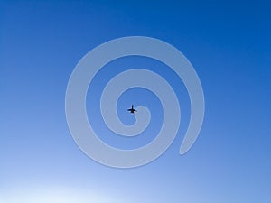 Airplane with two jet engines flying over the evening blue sky