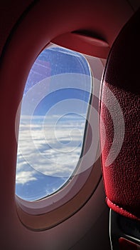 Airplane View, Airplane Window view, with blue sky and clouds from Porthole