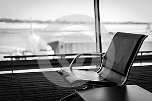 Airplane, view from airport terminal with empty seats in the airport waiting room near the gate. Travel concept with