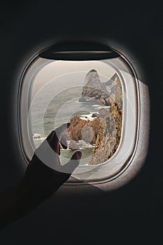 Airplane window with a aerial panorama of Ursa beach near Cabo da Roca in Portugal during a flight