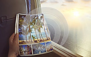 Airplane window with beautiful views of turquoise clear sea, palm trees and bright sunrise