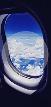 Airplane window with the clouds sky background