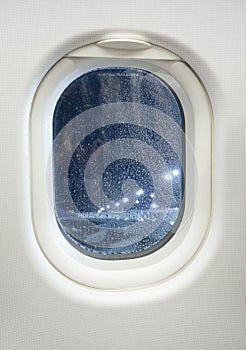 Airplane window view at night with raindrop