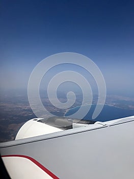 Airplane Window With Wing And clear Sky Behind